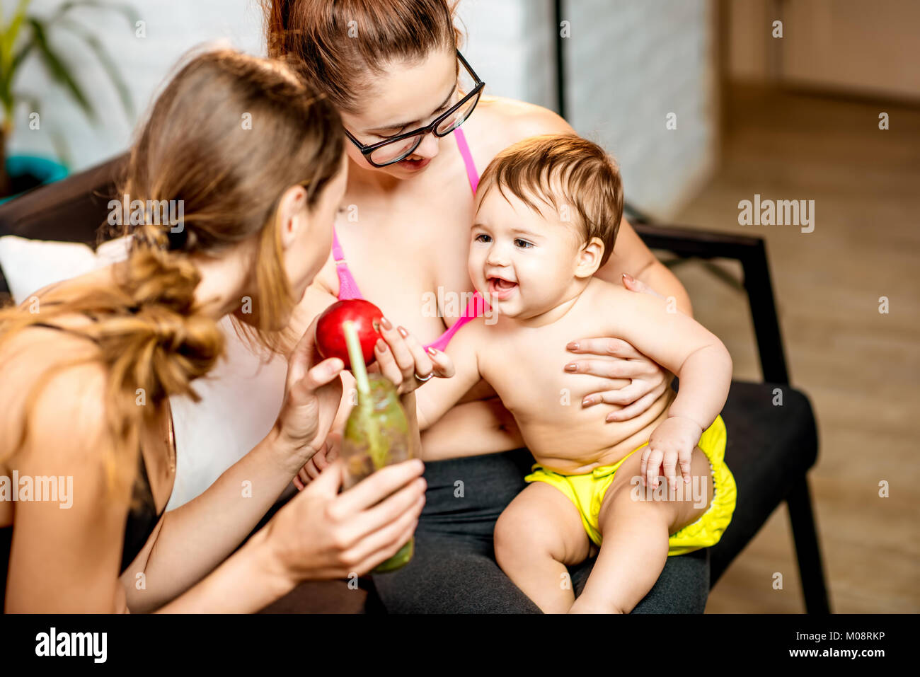 Sports moms with baby boy at home Stock Photo