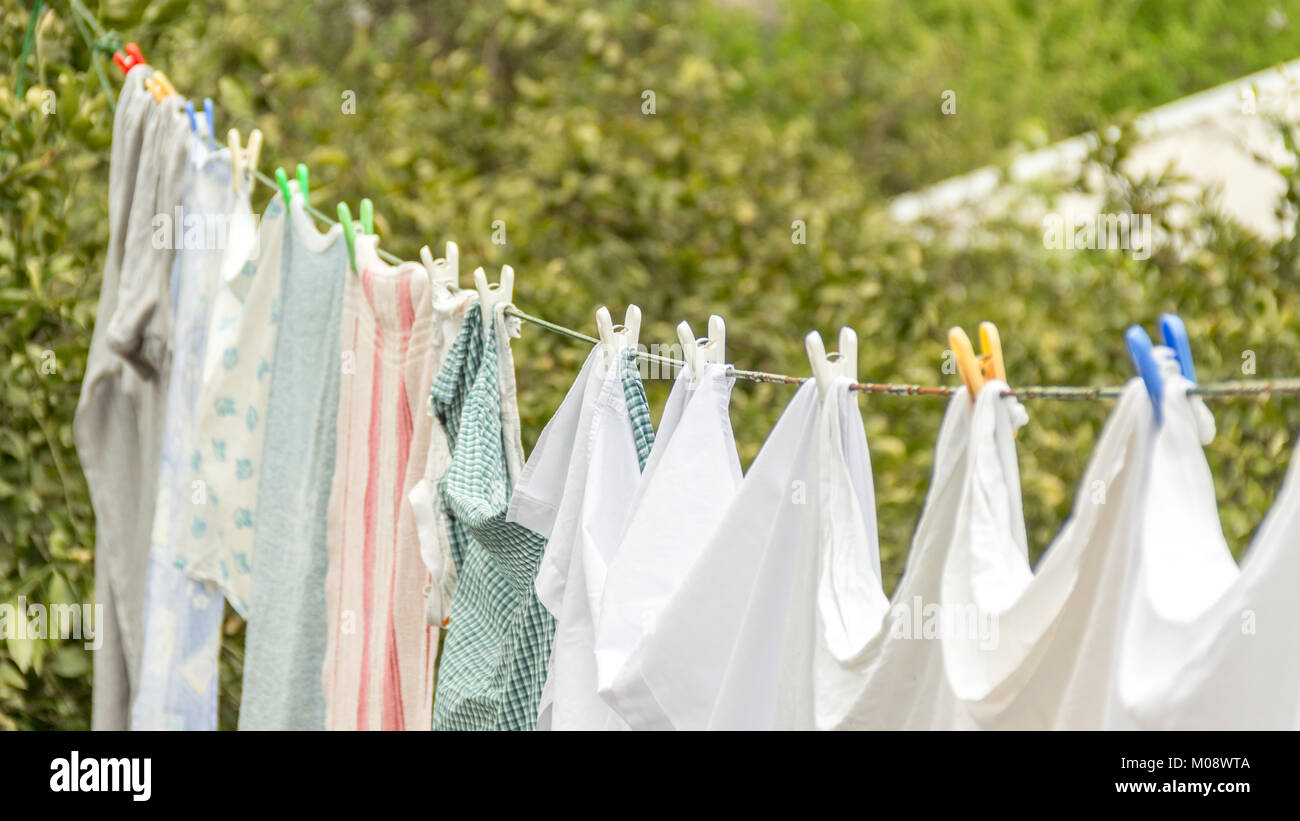 Laundry line with white clothes and green nature background. Stock Photo