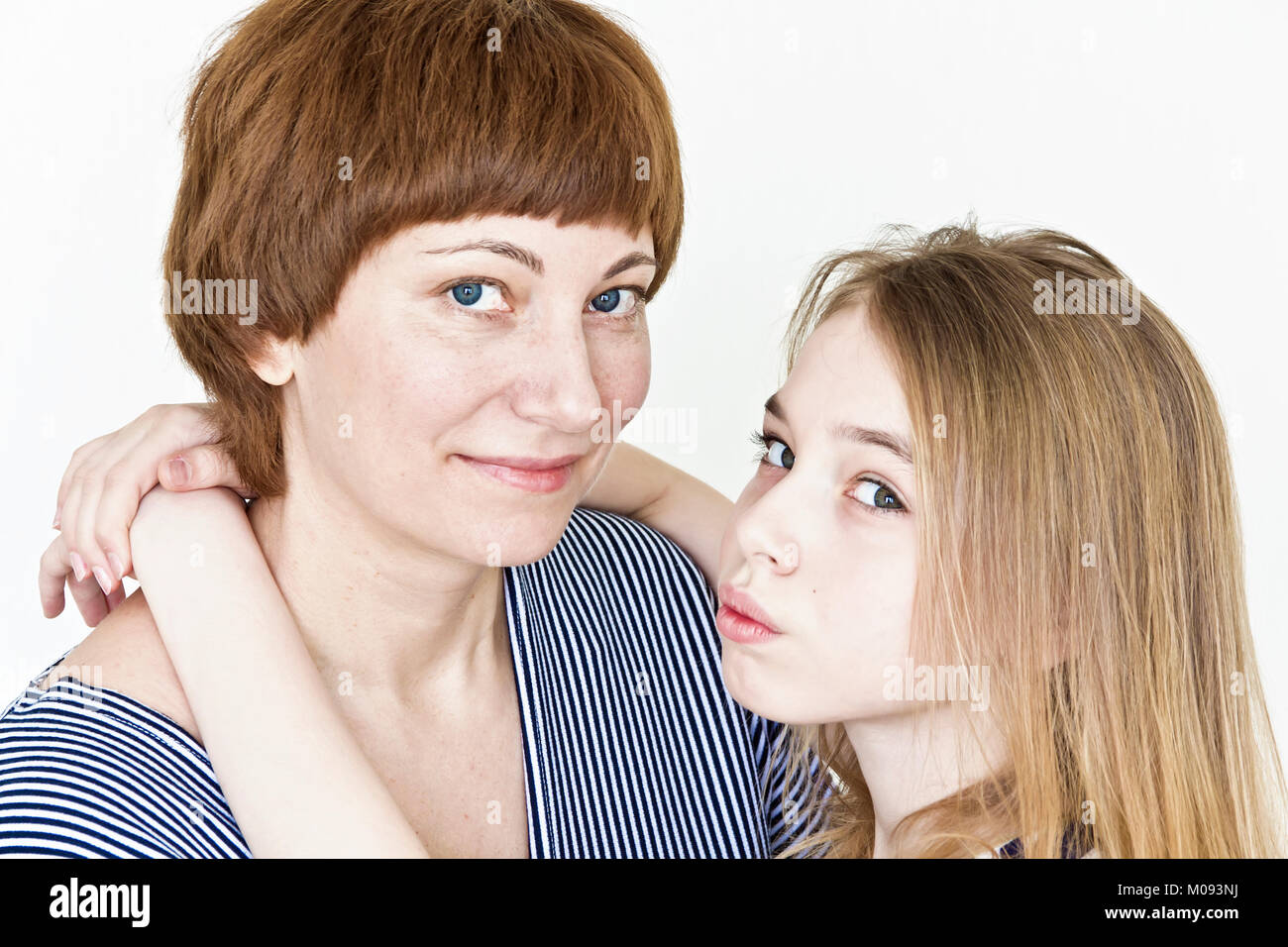 Mother And Daughter Playing With Blond Long Hair Near White Wall Stock