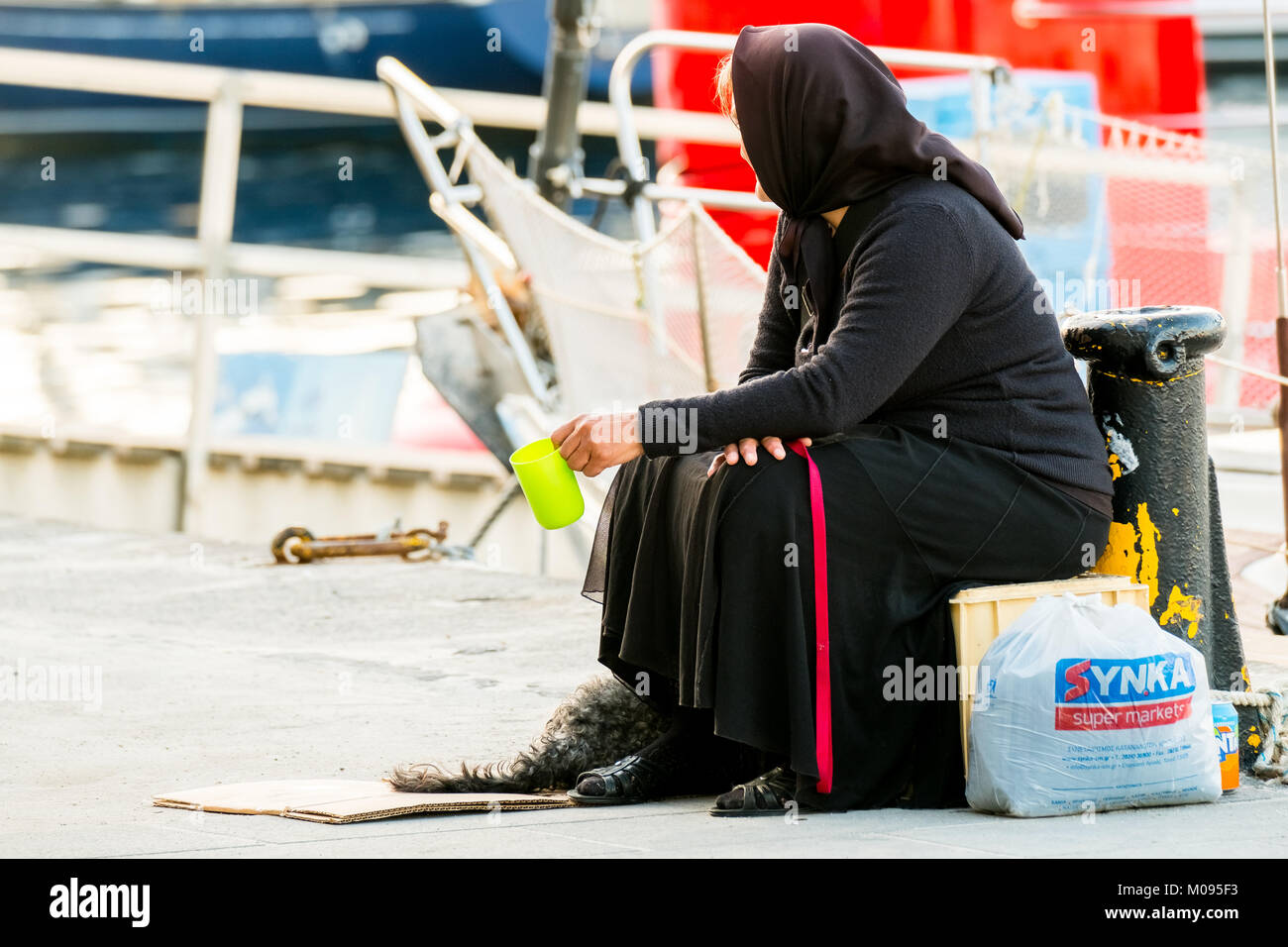 beggar woman in black robe in port of Chania, poverty, Europe, Crete, Greece, Chania, Europe, Crete, Greece, GR, travel, tourism, tourist destination, Stock Photo