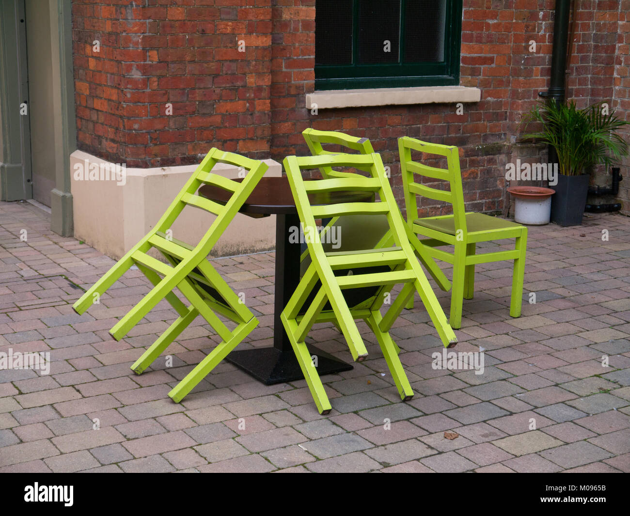 Four lime green chairs, three propped against a table, the Higgins Gallery, Bedford, UK Stock Photo