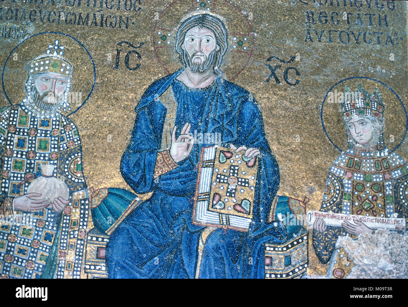 Byzantine Mosaic of Jesus Christ Holding a Bible flanked by Byzantine Emperor Constantine IX Monomachos (c1000-1055), reigned 1042-1055, Offering a Bag of Money, and Byzantine Empress Zoe Porphyrogenita in Hagia Sophia Church Museum, Sultanahmet, Istanbul, Turkey Stock Photo