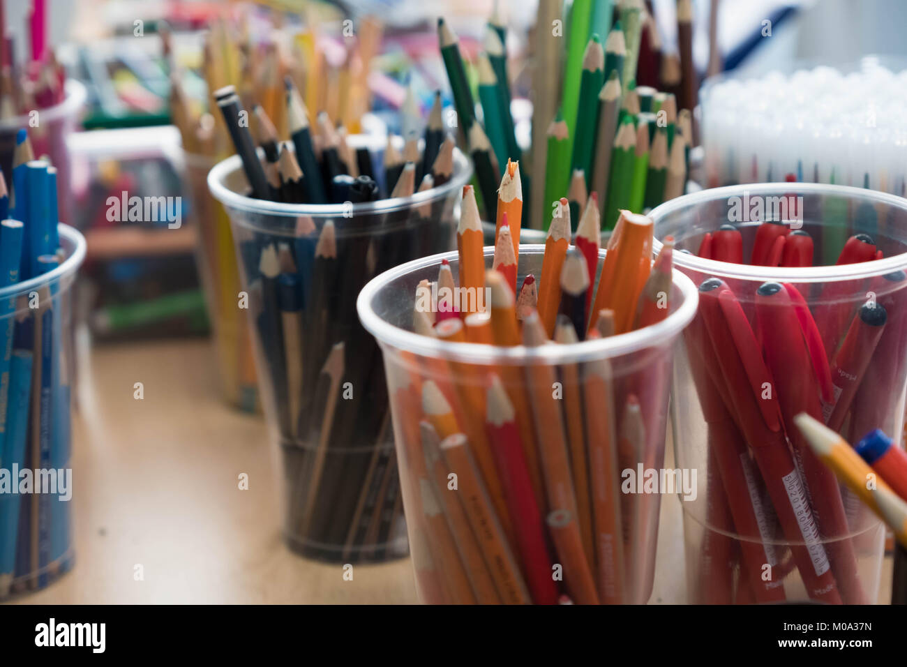 Pots of coloured pencils in a school classroom Stock Photo