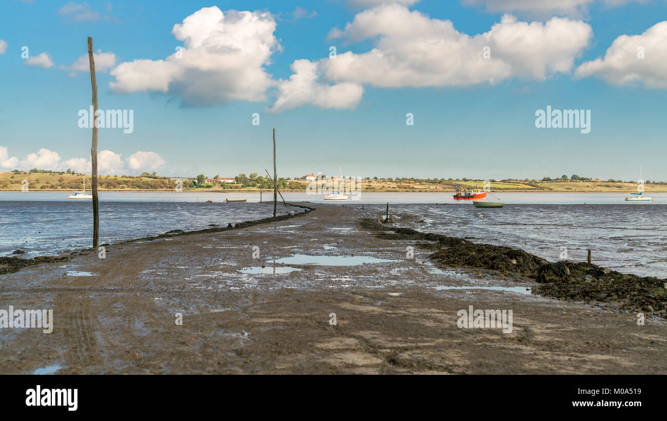 Boats in the Oare Marshes with the Isle of Sheppey in the background, near Faversham, Kent, England, UK Stock Photo