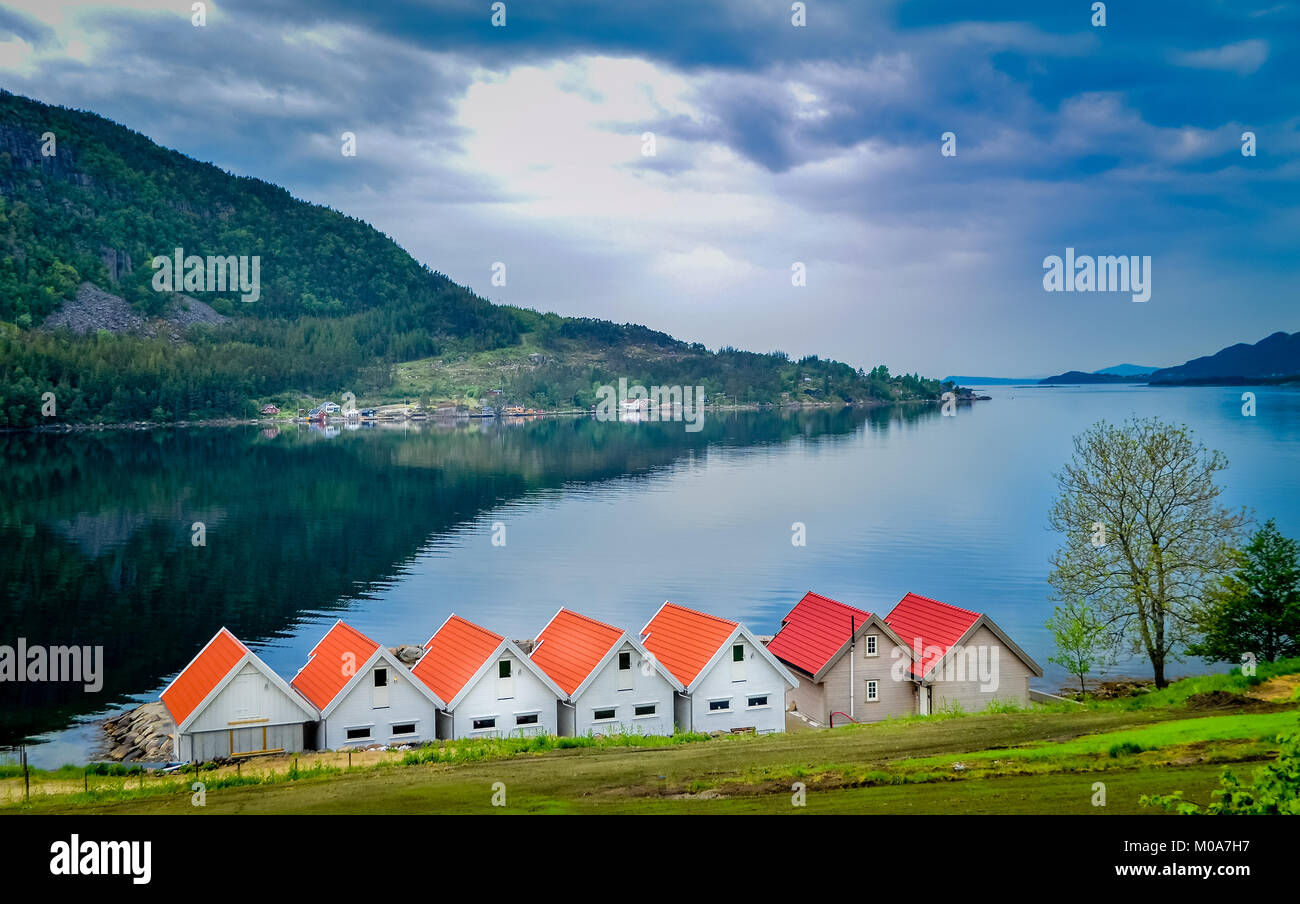 Lovely Orange huts or cottages lined up a the coast in Norway Stock Photo