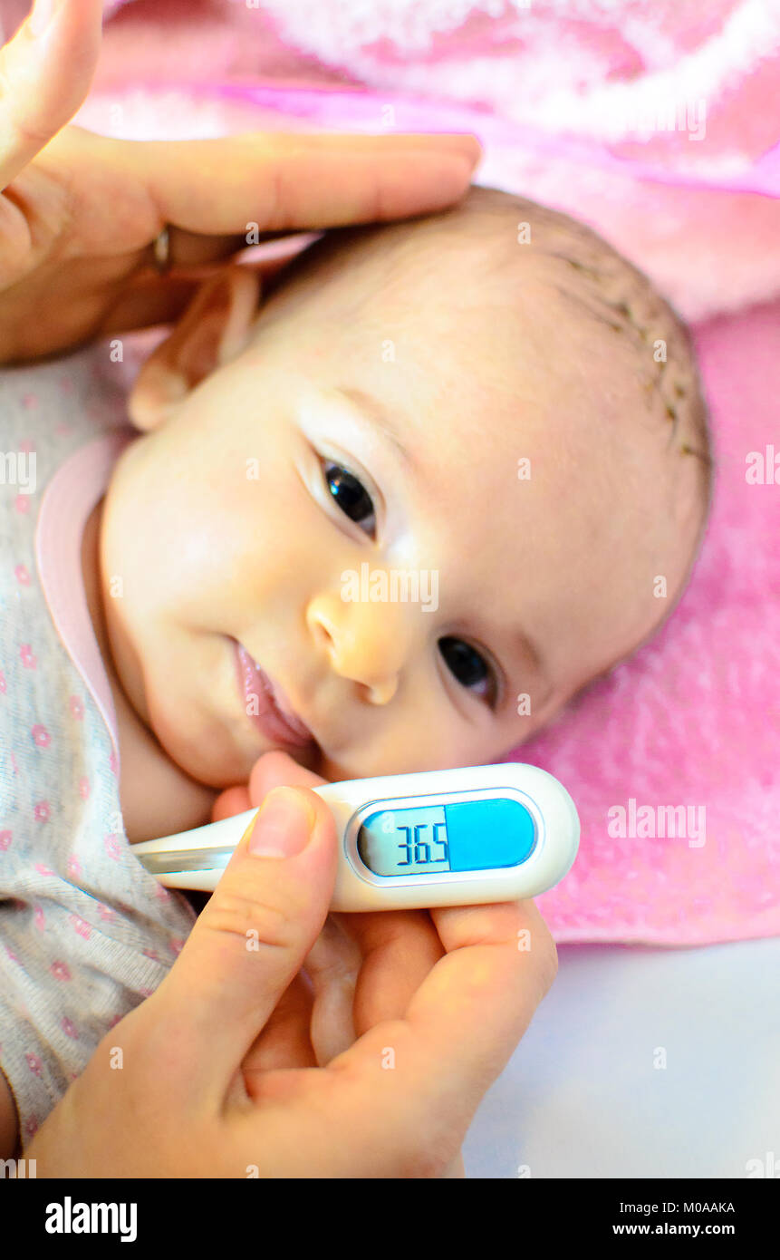 newborn baby flu child temperature measure thermometer fever Stock Photo