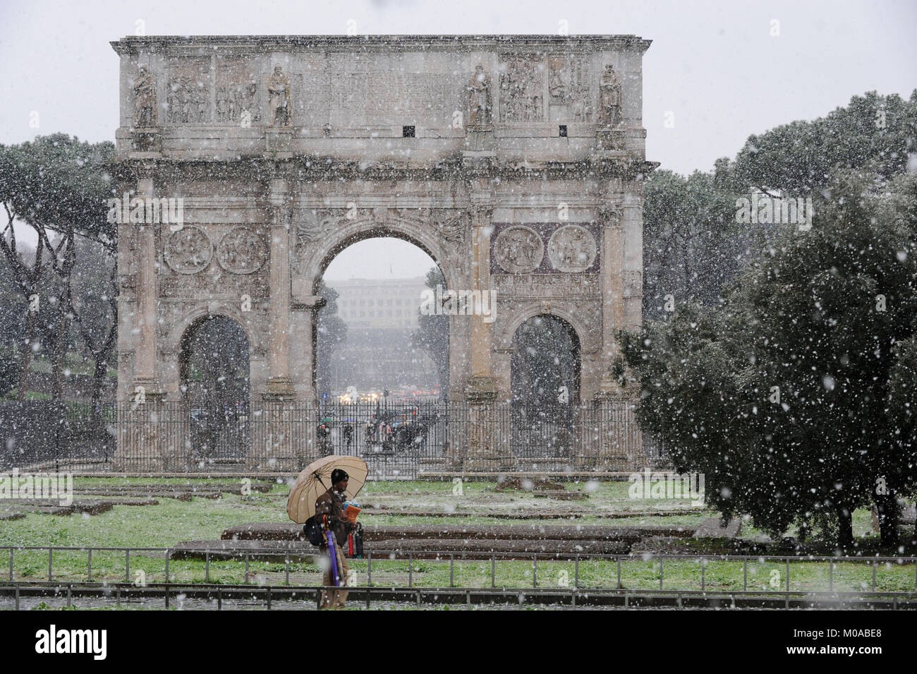 Rome, Italy. Itinerant seller of  umbrellas during heavy snowfall, Traiano Arch. Stock Photo