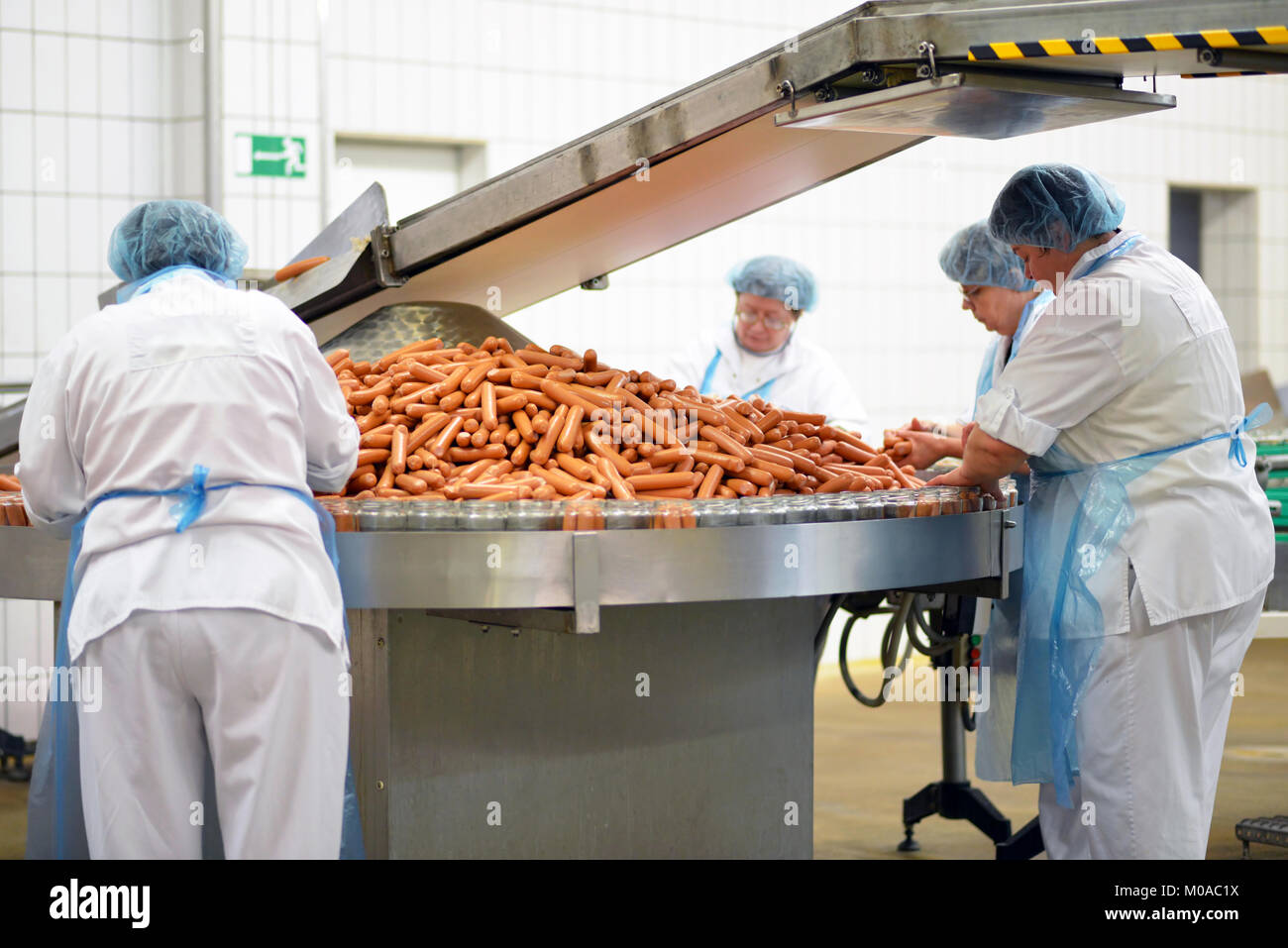 food industry workers in the production of original German bratwurst in a large butcher's shop