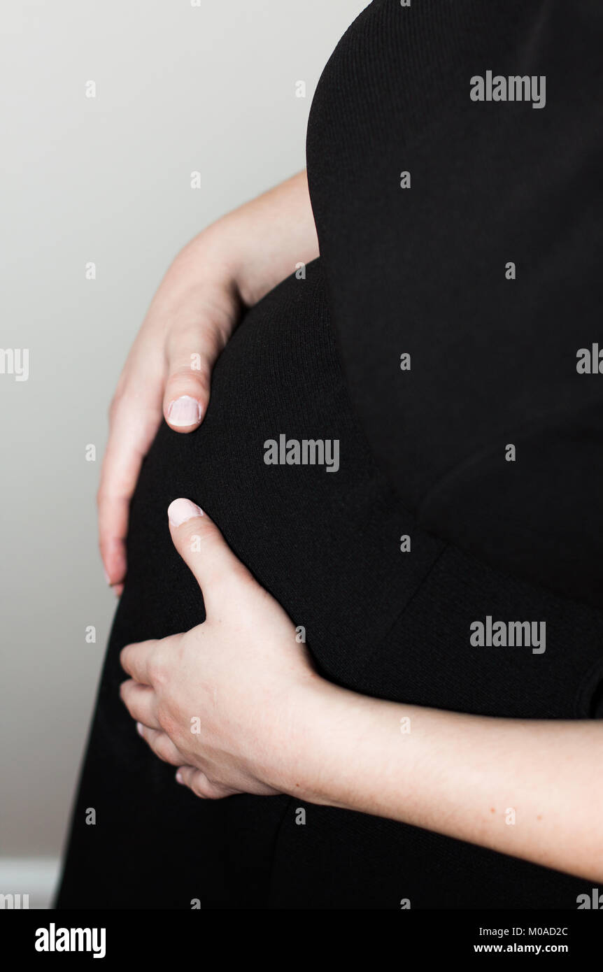 Expectant Mother holding her tummy Stock Photo