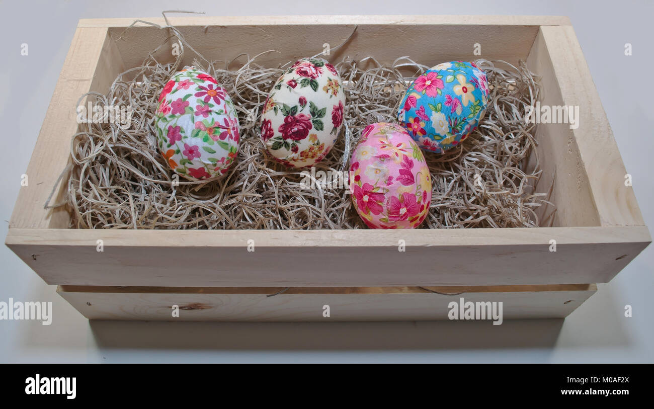 Straw Easter basket filled with eggs of different colors and patterns  against a white background Stock Photo - Alamy