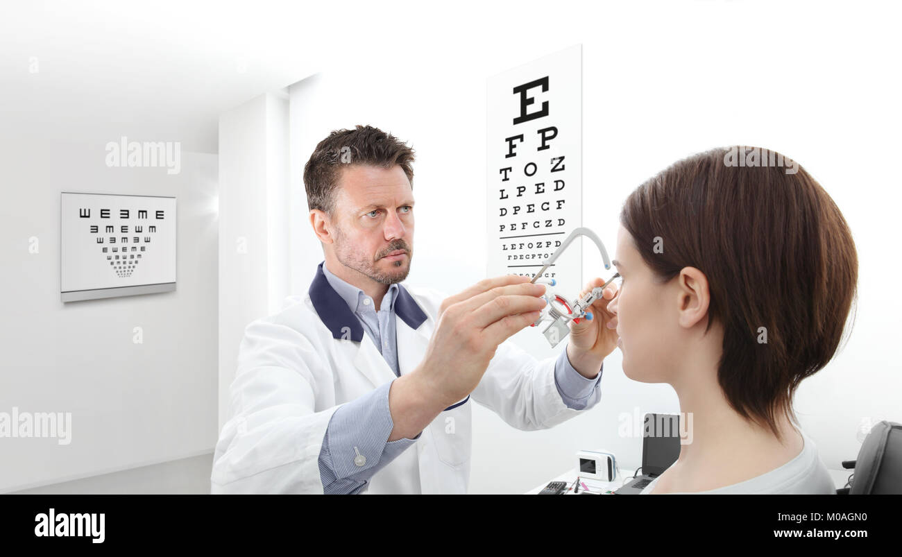 optometrist with trial frame examining eyesight  woman patient in optician office Stock Photo