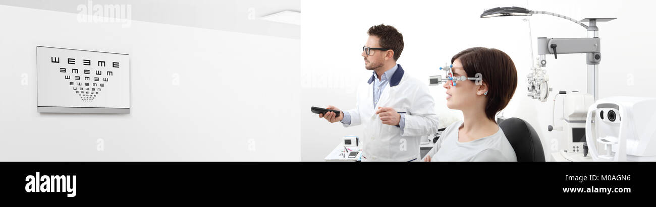 woman in the optometrist office examining her eyesight, he is pointing at the chart monitor remote controller, eye care concept, web banner template Stock Photo