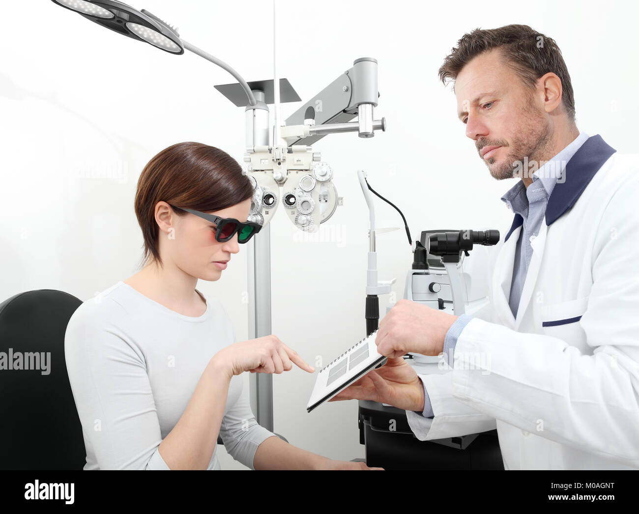 optometrist examining eyesight  woman patient in optician office, stereo test Stock Photo