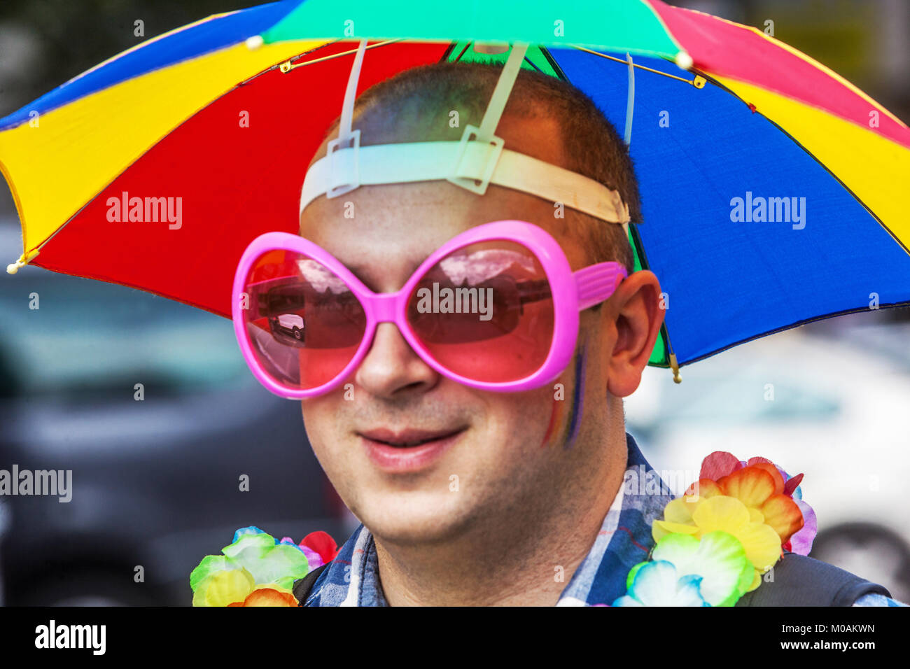 LGBT fashion, man with pink sunglasses and umbrella hat Stock Photo