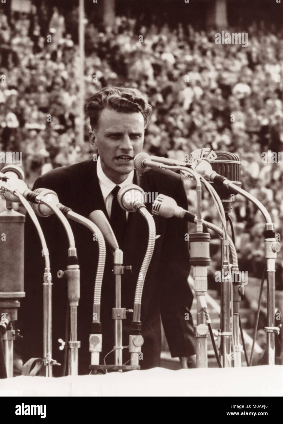 American evangelist Billy Graham addressing a crowd of over 100,000 at the Olympic Stadium in Berlin, Germany in June, 1954. Stock Photo