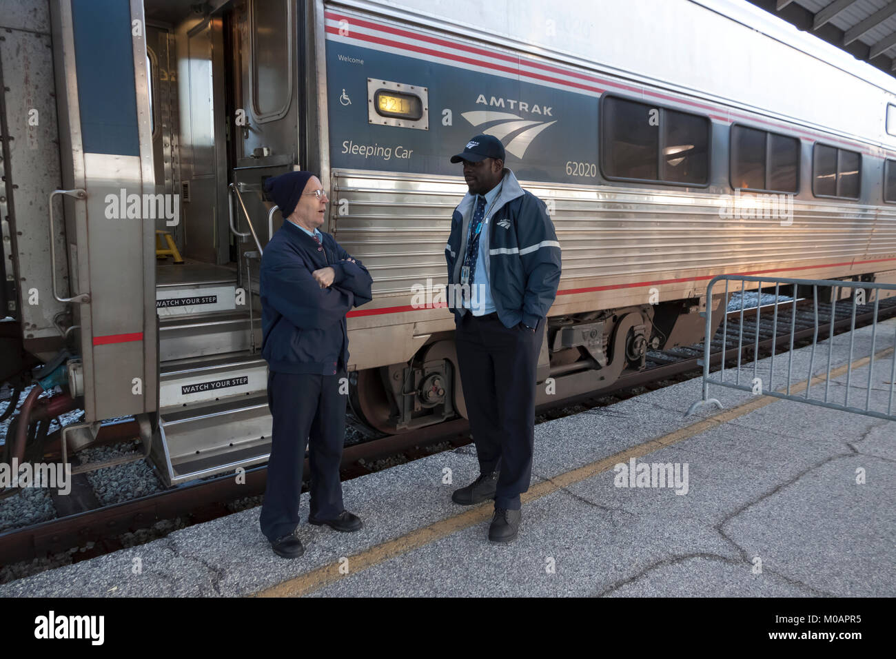 Two male Amtrak porter employees having a conversation while at a station break in Florida. Stock Photo