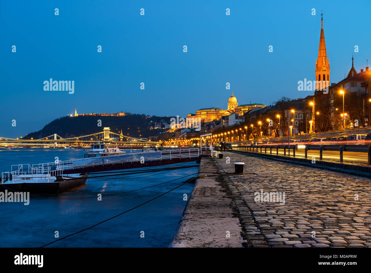 Danube waterfront in Pest with a view over Chain Bridge and Buda Castle at night Stock Photo