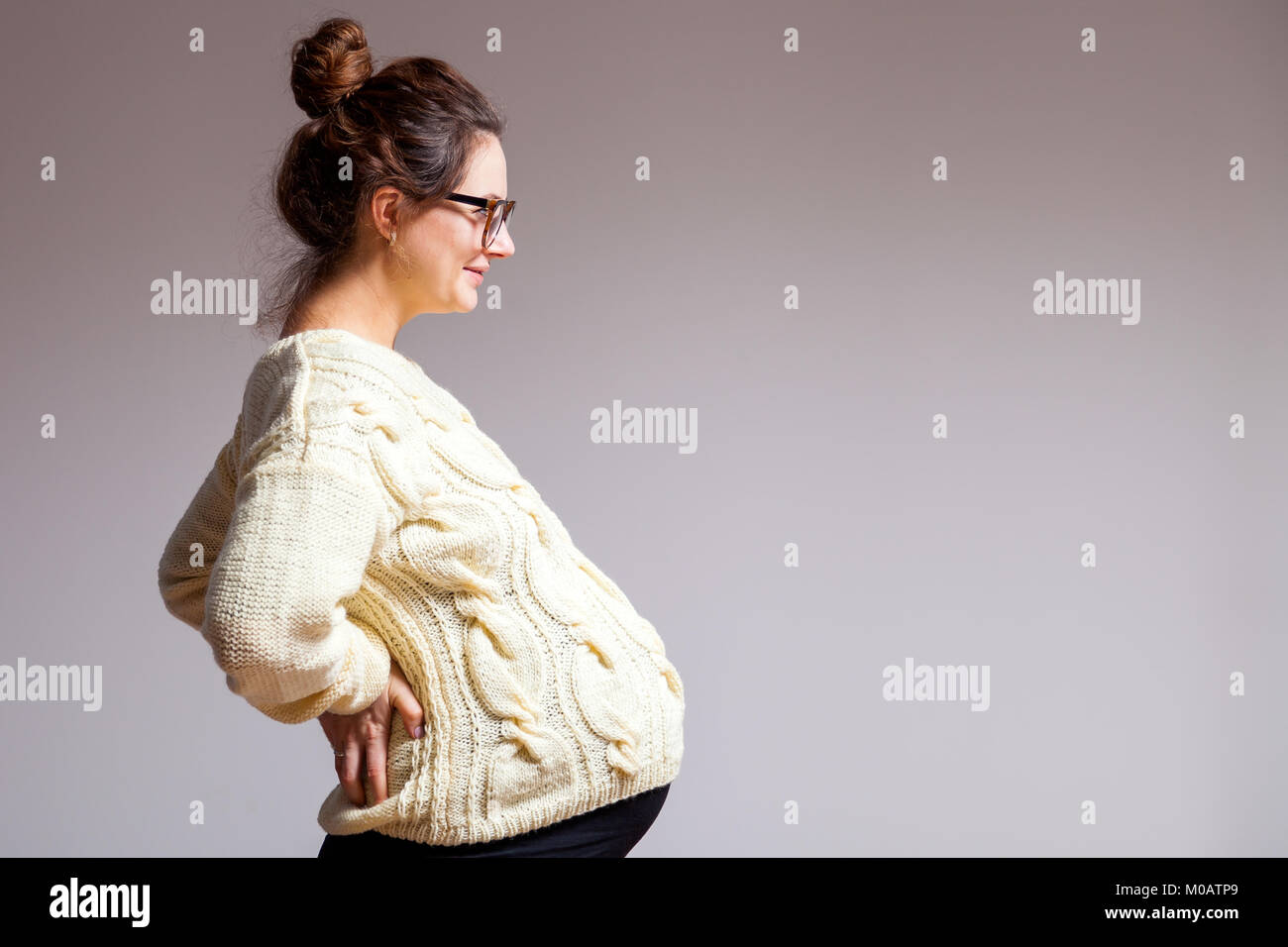 Young darkhaired beautiful woman in late pregnancy with glasses and