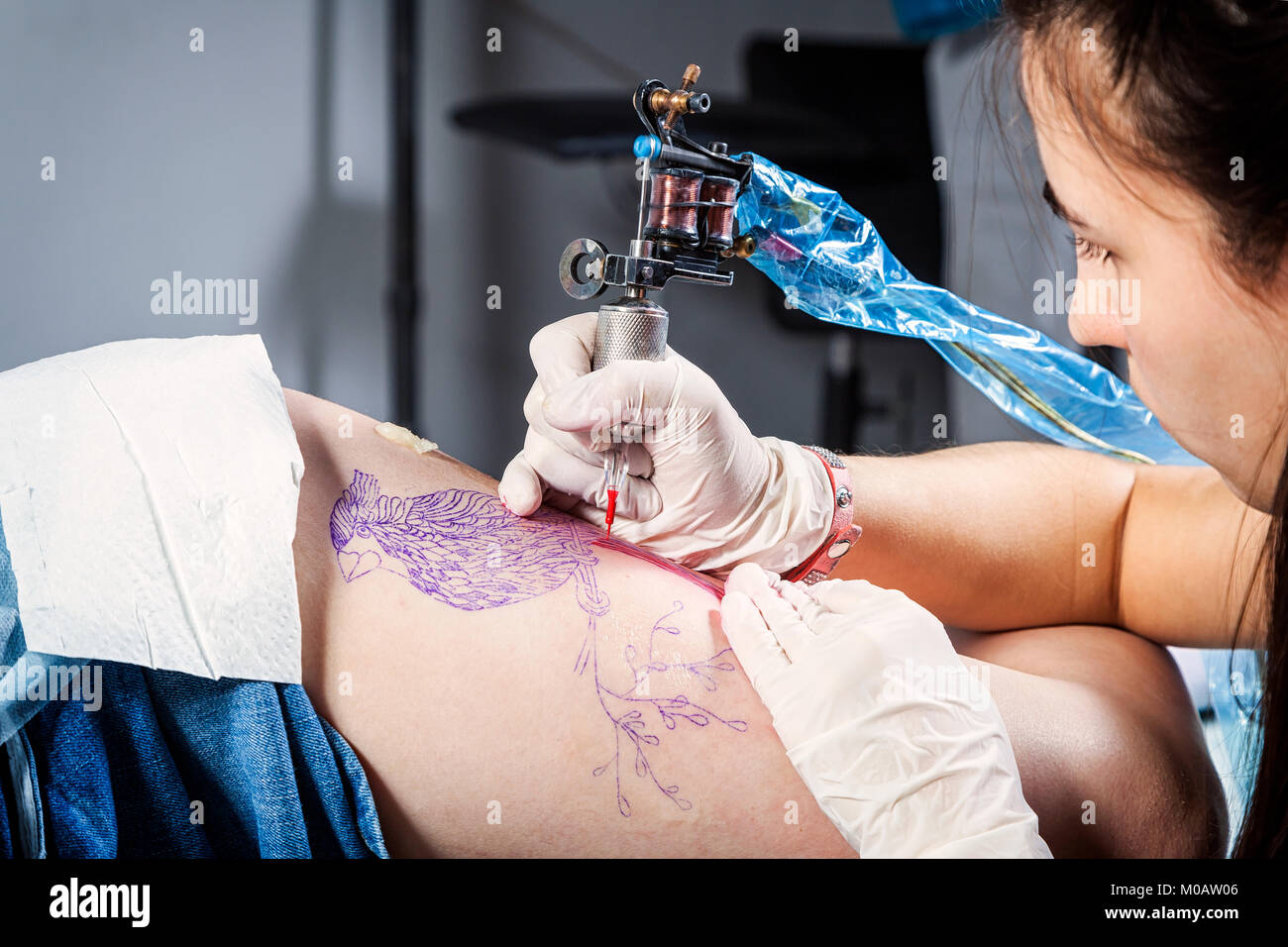 Close up of the tattooist making by professional artist is tattooing body woman using machine in a creative design work studio Stock Photo - Alamy Close up of the tattooist making by professional artist is tattooing body woman using machine in a creative design work studio Stock Photo - Alamy