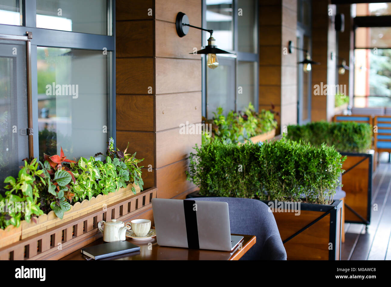 Close up laptop and black notebook on restaurant table Stock Photo - Alamy