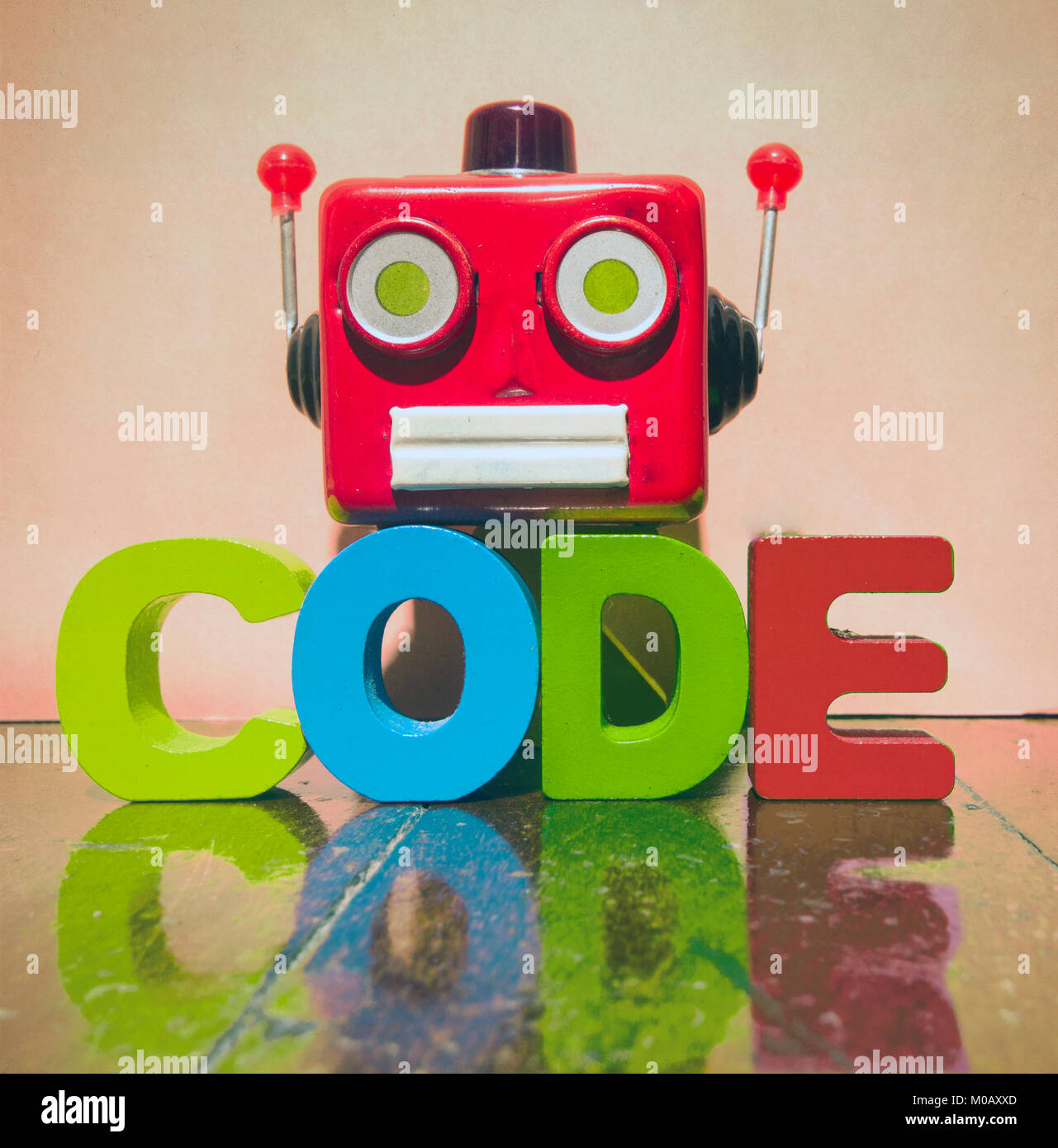 retro red robot head and the word CODE on a old wooden floor Stock Photo