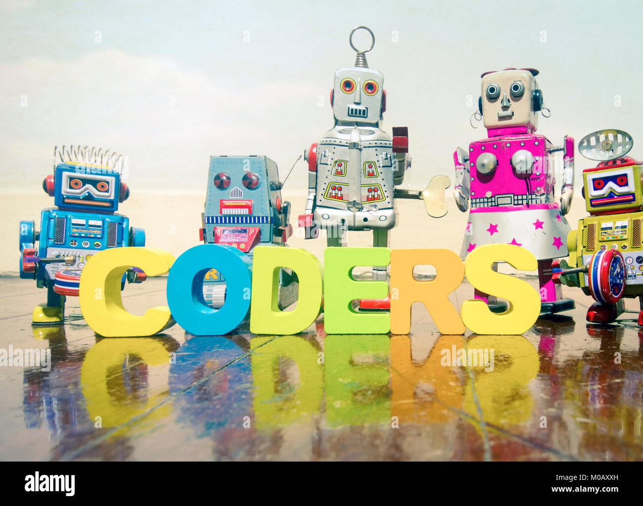 a team of robit toy coders on an old wooden floor  with reflection Stock Photo