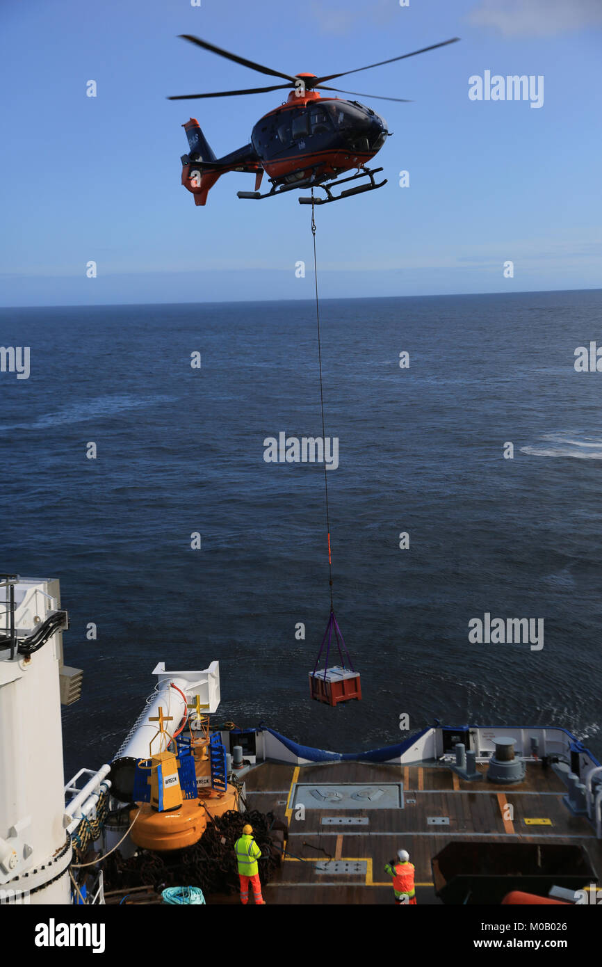 helicopter slinging building material from an irish offshore island, wild atlantic way, county mayo, ireland Stock Photo