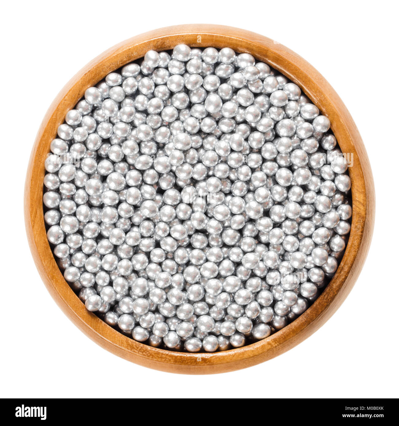 Silver nonpareils in wooden bowl. Hundreds and thousands. Decorative confectionery of tiny balls, made with sugar and starch, used for decoration. Stock Photo