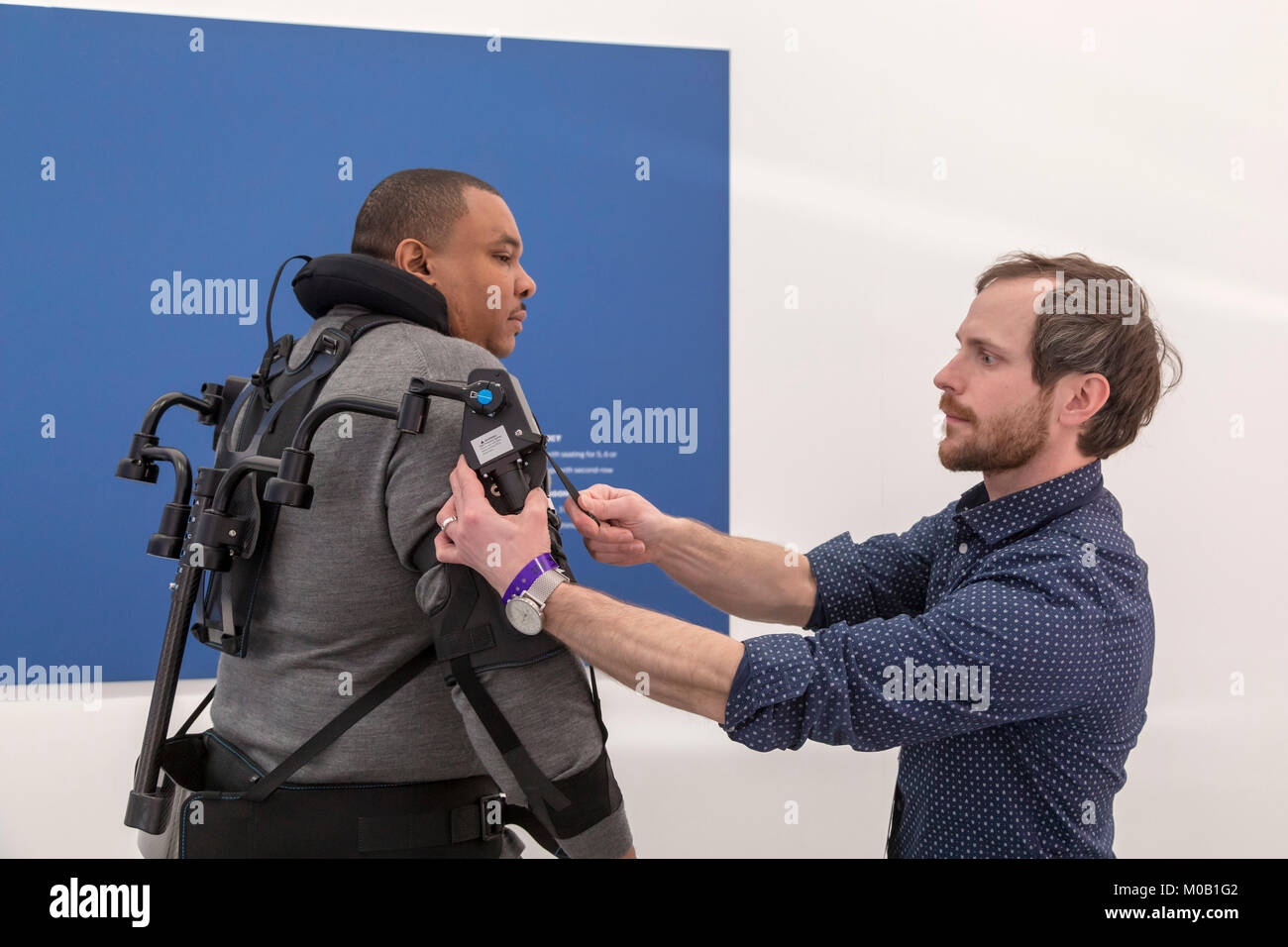 Detroit, Michigan - Marty Smets adjusts an exoskeleton worn by Carlo Bishop, both of Ford Motor Company, at the North American International Auto Show Stock Photo