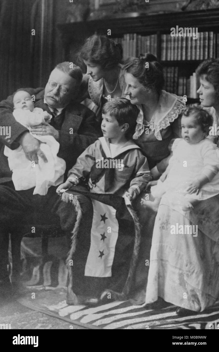 Teddy Roosevelt holds a baby in his arms in a Family Portrait Stock Photo