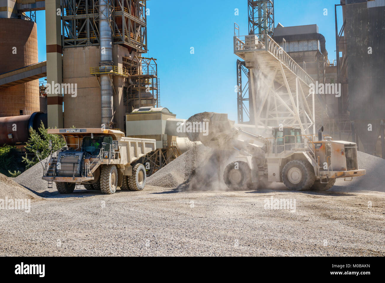 Wheel loader fills a Caterpiller dump truck with marl at the Mount Saint Peter ENCI (First Dutch Cement Industry) quarry, Maastricht, The Netherlands. Stock Photo