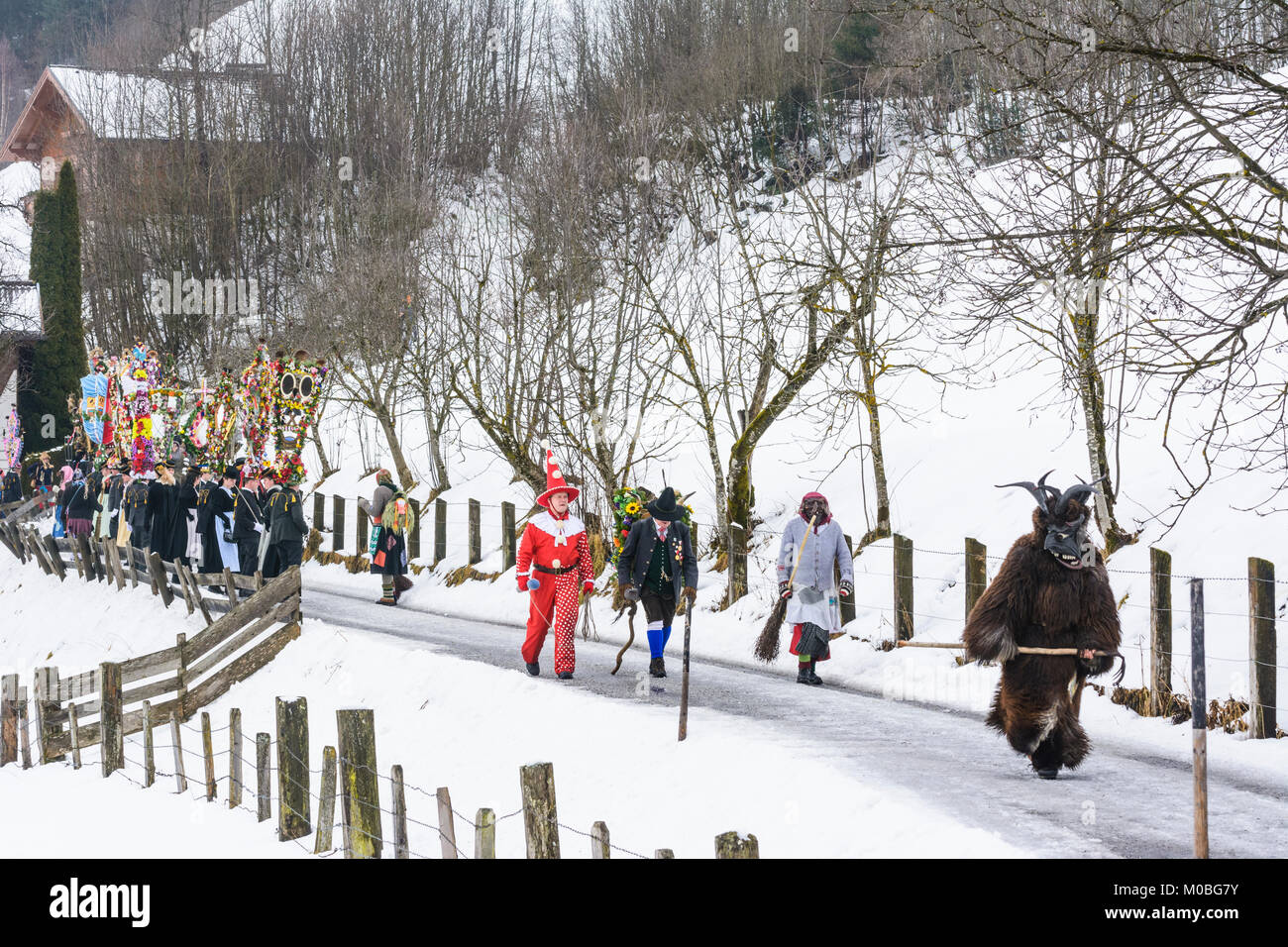 Bad Hofgastein: Perchtenlauf (Percht Perchten mask procession): Vorteufel (front devil), schöne Bajazzl (Hanswurst), Kappenträger mit Nachtänzer (cap  Stock Photo