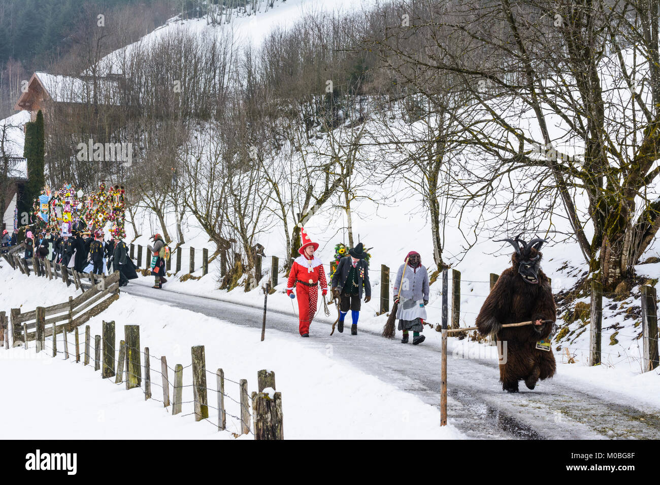 Bad Hofgastein: Perchtenlauf (Percht Perchten mask procession): Vorteufel (front devil), schöne Bajazzl (Hanswurst), Kappenträger mit Nachtänzer (cap  Stock Photo