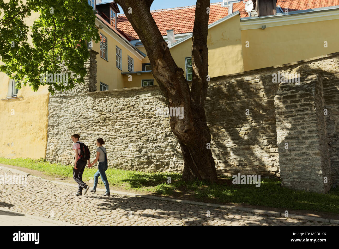 Tallinn, Estonia - June 10, 2017: Young people walking on the street of Old city. The Old Town is one of the best preserved medieval cities in Europe  Stock Photo
