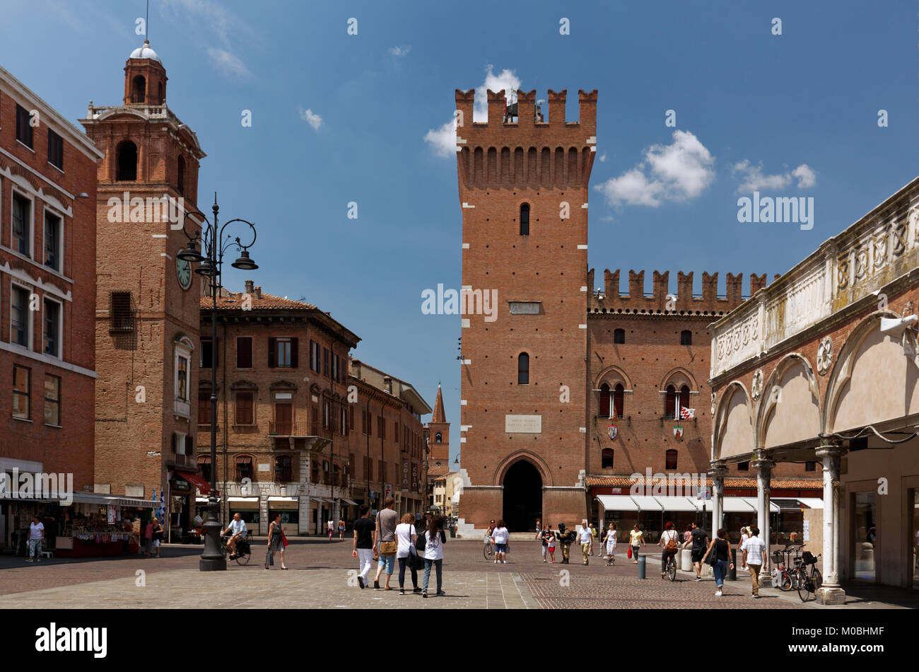 Ferrara, Italy - June 17, 2017: People walking on Piazza Trento against the Ferrara Town Hall. Begun in 1245, the City Hall was the residence of the E Stock Photo