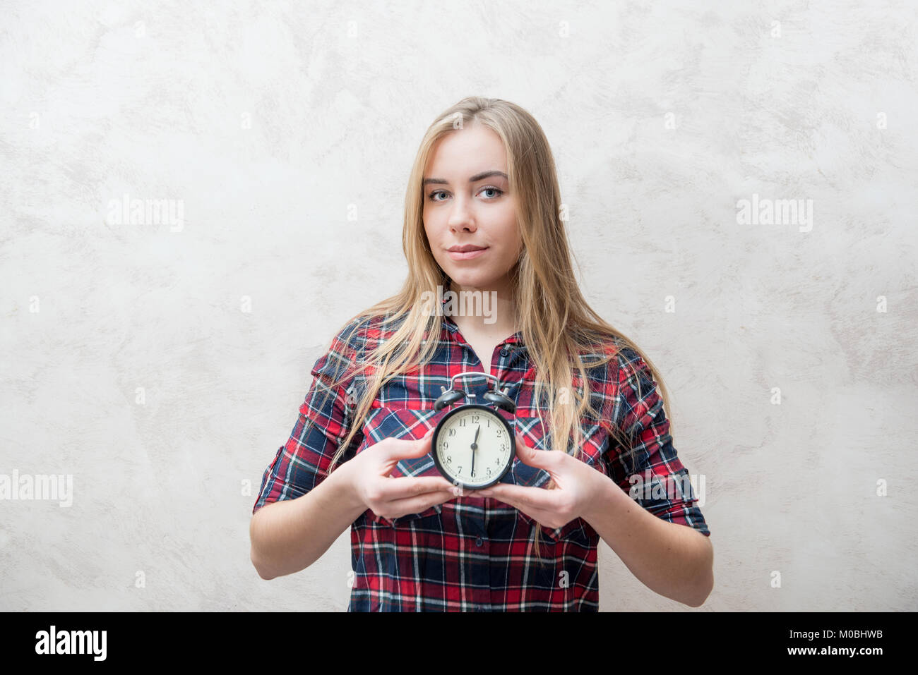 Young blond hair woman and alarm clock concept of time, dating, deadline, offer, occasion, event Stock Photo