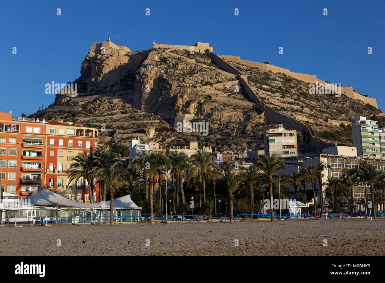 Alicante, Spain - January 08, 2013: View to Santa Barbara castle from the beach. Situated on the slopes of Mount Benacantil, the castle originated in  Stock Photo