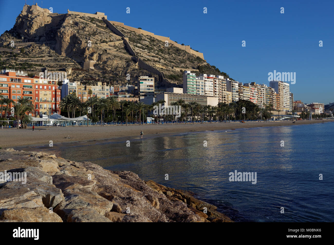 Alicante, Spain - January 08, 2013: View to Santa Barbara castle from the beach. Situated on the slopes of Mount Benacantil, the castle originated in  Stock Photo