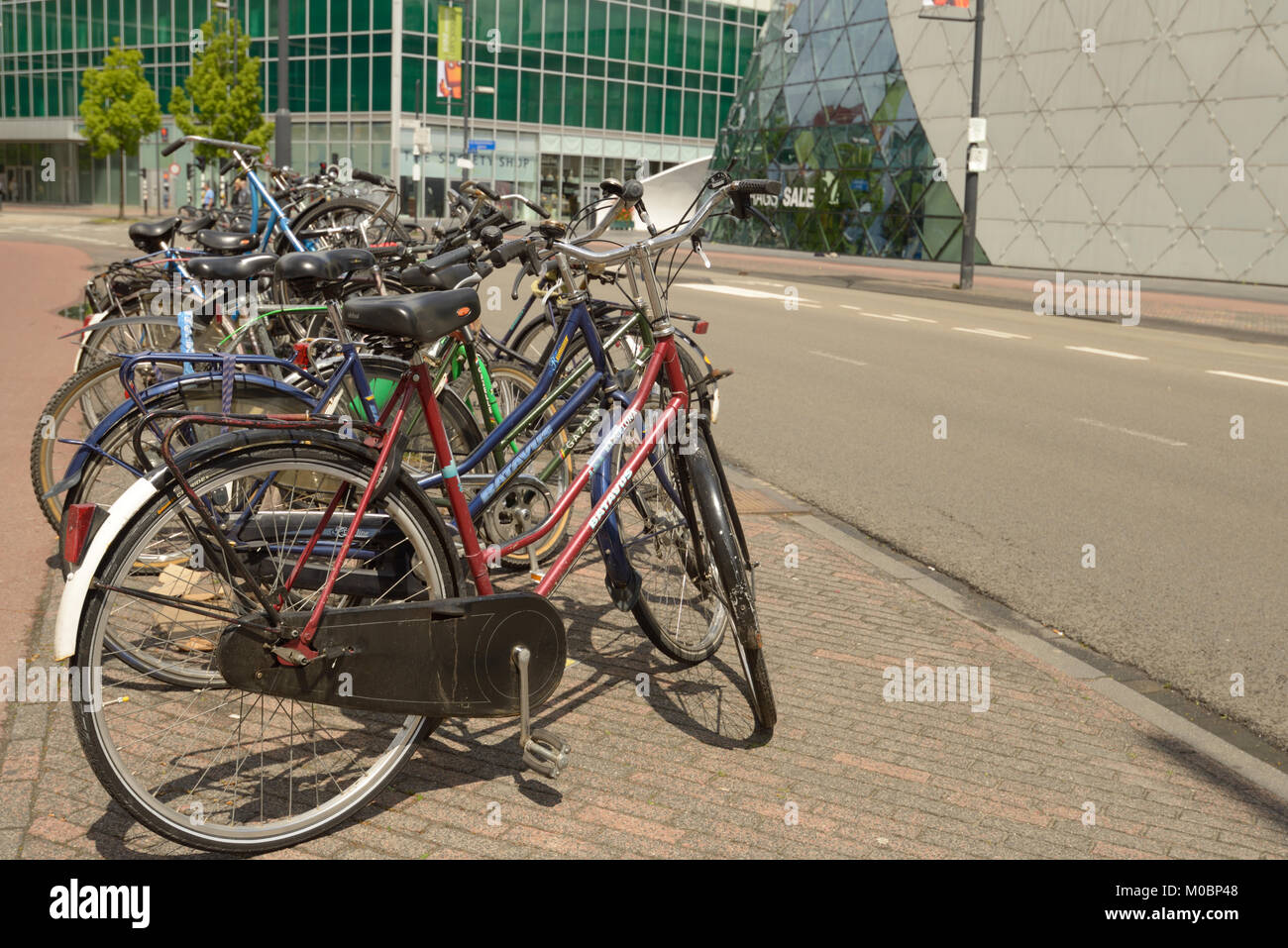 Eindhoven, Netherlands - June 23, 2013: Bicycle parking against the futuristic The Blob building. The bike is considered as an element of real Dutch l Stock Photo