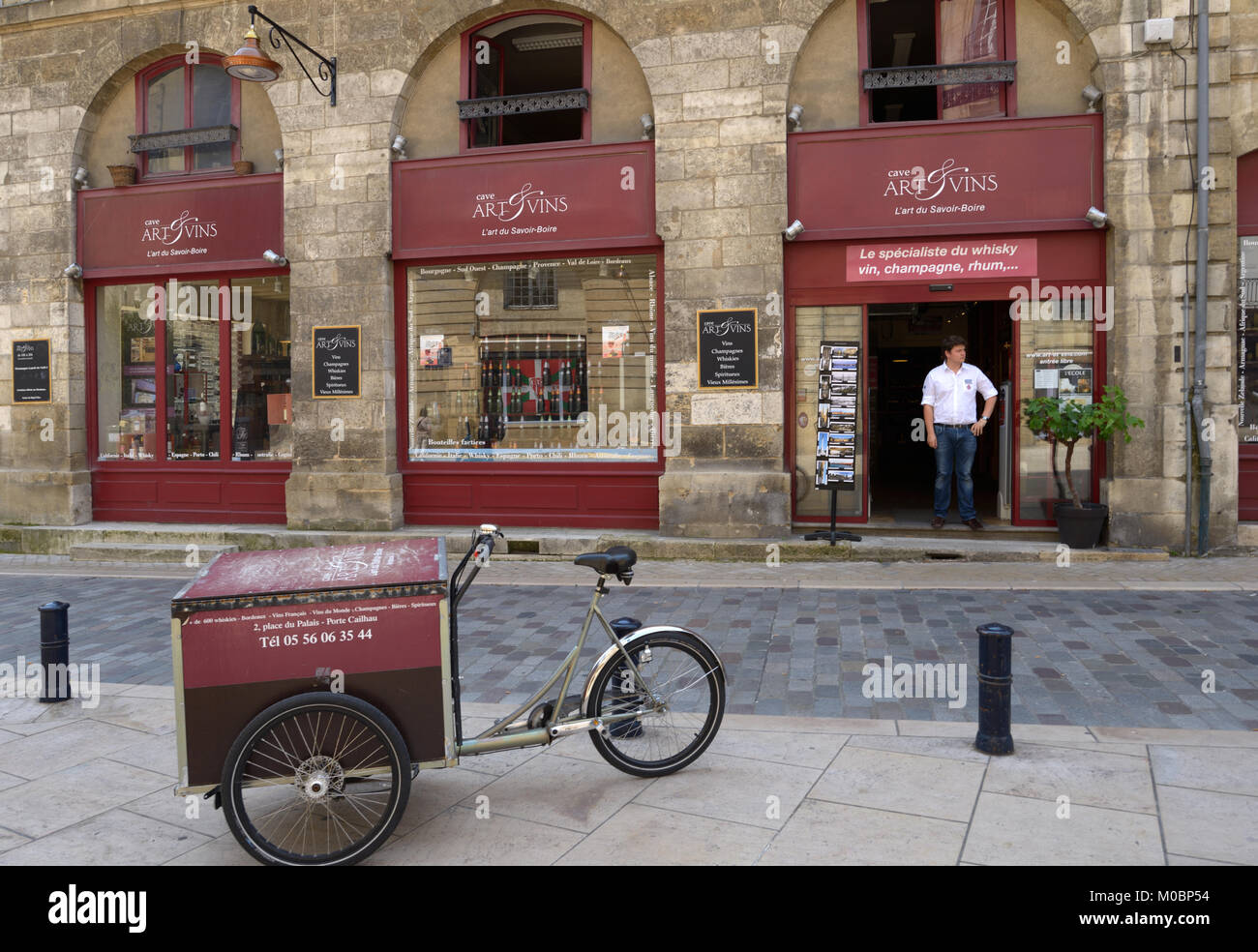 Bordeaux, France - June 27, 2013: Man in doors of the cafe Art Et Vins on the Palace square. This wine trading house works only with authentic wines a Stock Photo