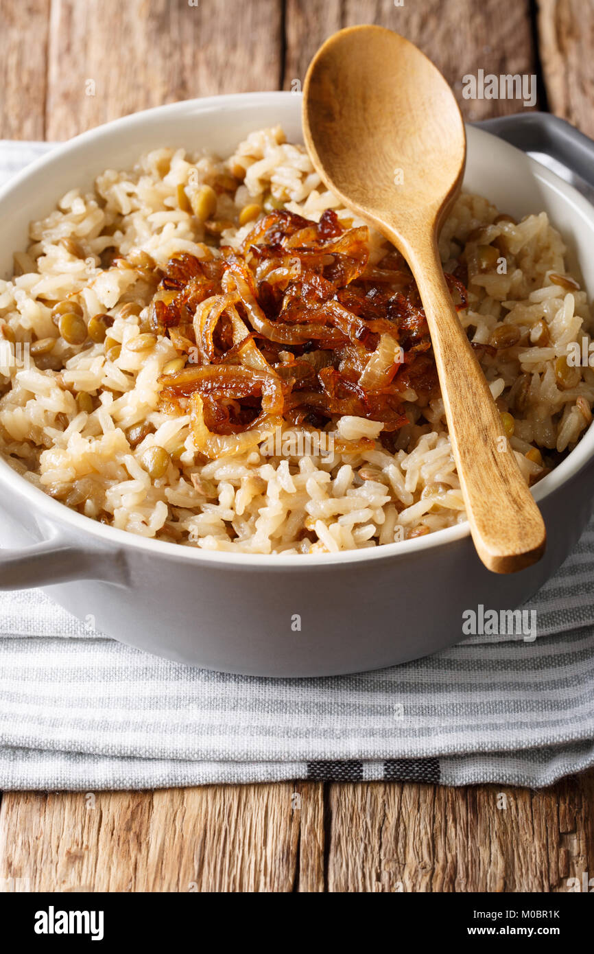 Arabic cuisine: rice with lentils and fried onions close-up in a bowl on the table. vertical Stock Photo