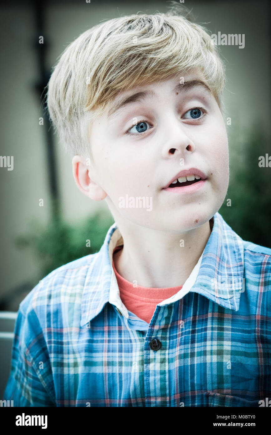 blond haired boy, 12 years old, looking quizzical, surprised, on holiday at the seaside Stock Photo