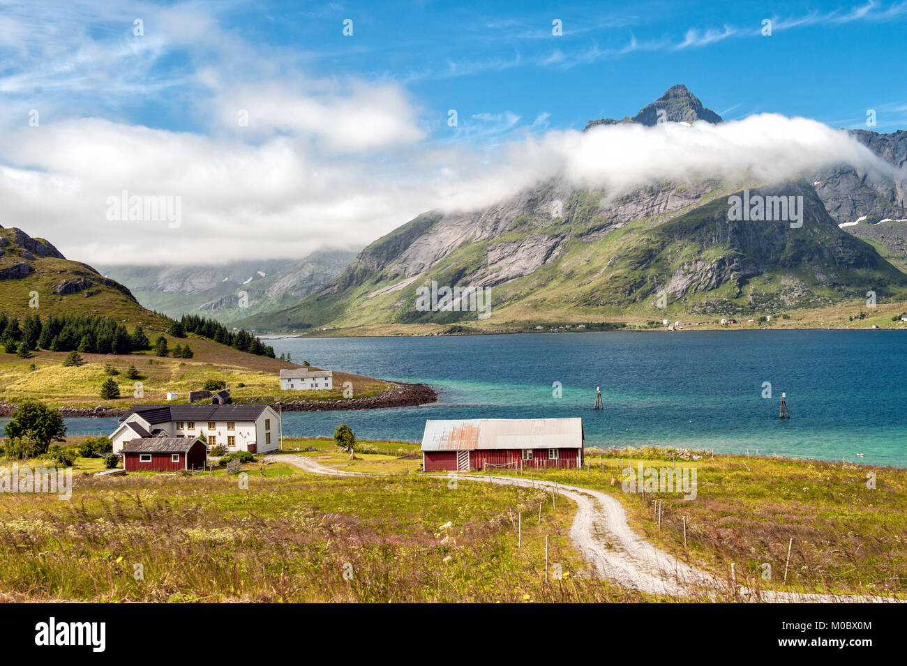 Traditional farm buildings in coast landscape on Lofoten islands in northern Norway. Lofoten is a popular tourist destination. Stock Photo