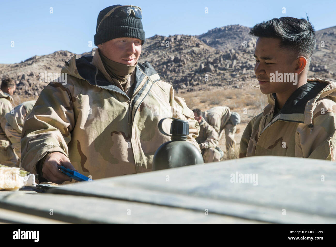 U.S. Marine Corps Sgt. Johnathon Rhodes, left, and Lance Cpl. Xavier Swank, right, both Chemical, Biological, Radioactive and Nuclear defense specialists, with 1st Tank Battalion, 1st Marine Division, give a class about chemical warfare to Delta Company during exercise Steel Knight 2018 at Marine Corps Air Ground Combat Center, Twentynine Palms, Calif., Dec. 7, 2017. Exercise Steel Knight is a 1st Marine Division exercise conducted to successfully demonstrate the capability to exercise command and control over forces in a distributed environment with long range movement, while conducting offen Stock Photo