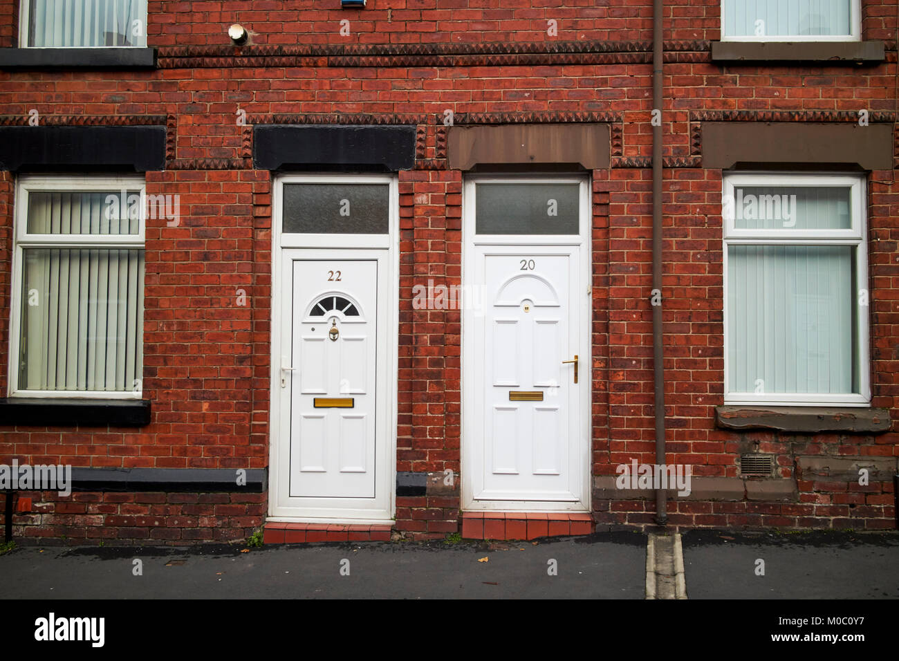 modern white pvc doors on two bedroomed red brick victorian terraced houses ward street st helens merseyside uk Stock Photo