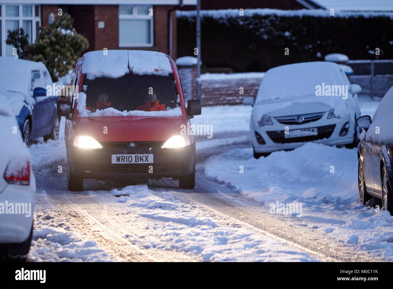 postmen driving royal mail van along street covered in snow in newtownabbey northern ireland Stock Photo