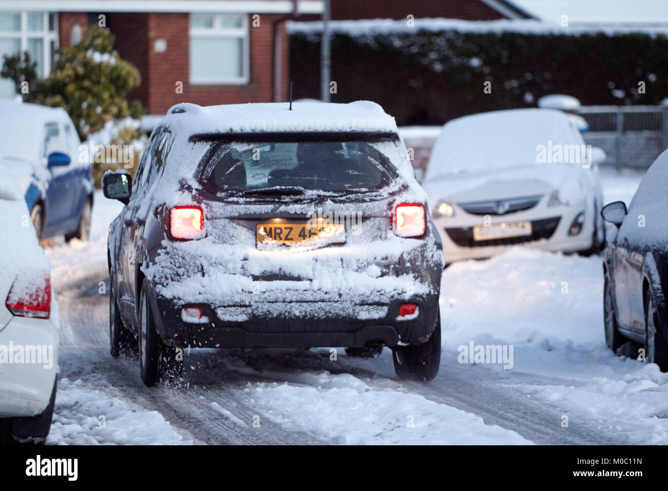 4x4 suv driving along street covered in snow in newtownabbey northern ireland Stock Photo