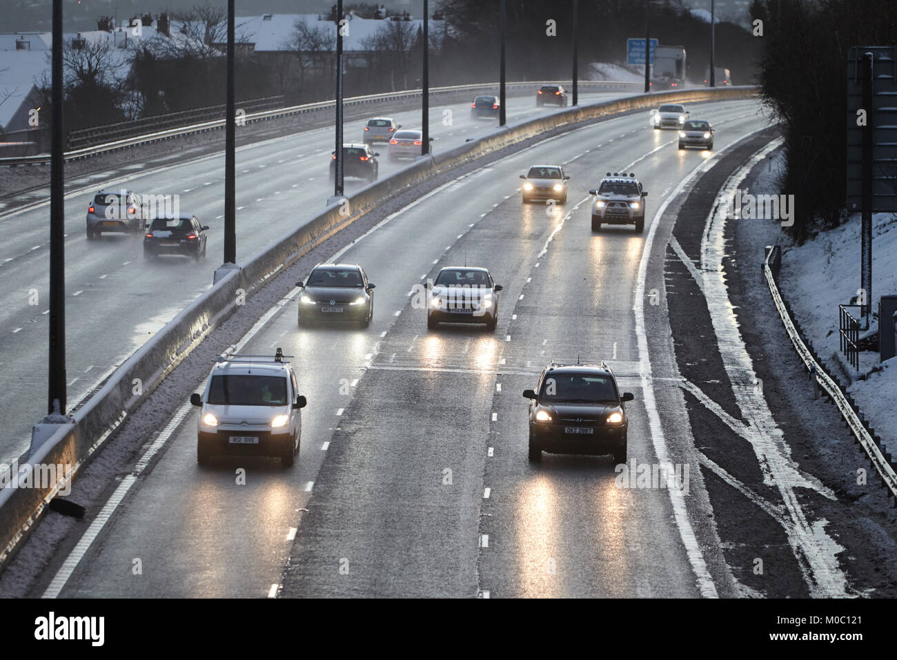 cars driving along gritted salted motorway in newtownabbey northern ireland Stock Photo