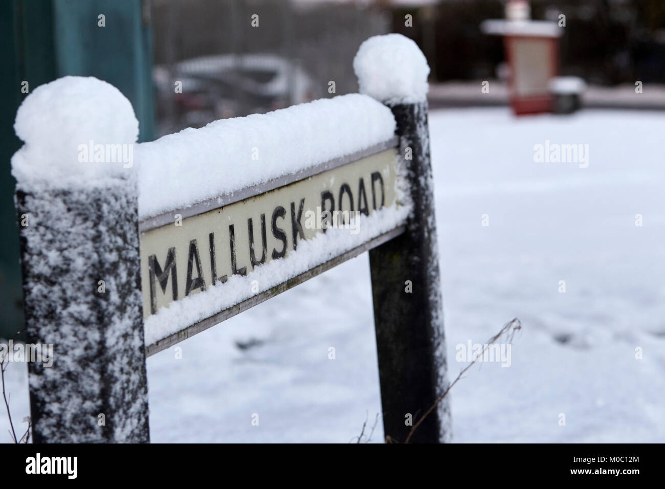 street sign for mallusk road covered in snow in newtownabbey northern ireland Stock Photo
