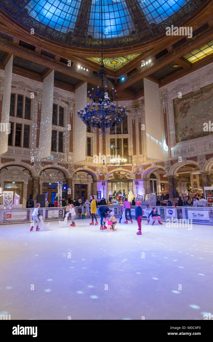 Children are skating on the ice rink inside the Chamber of Commerce in Lille, France Stock Photo